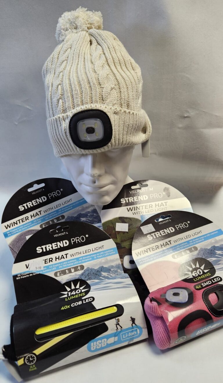 Čiapka so zabudovaným LED svetlom značky STRAND PRO, umiestnená na buste, obklopená baleniami ďalších čiapok so svetlom rôznych veľkostí a výkonov.